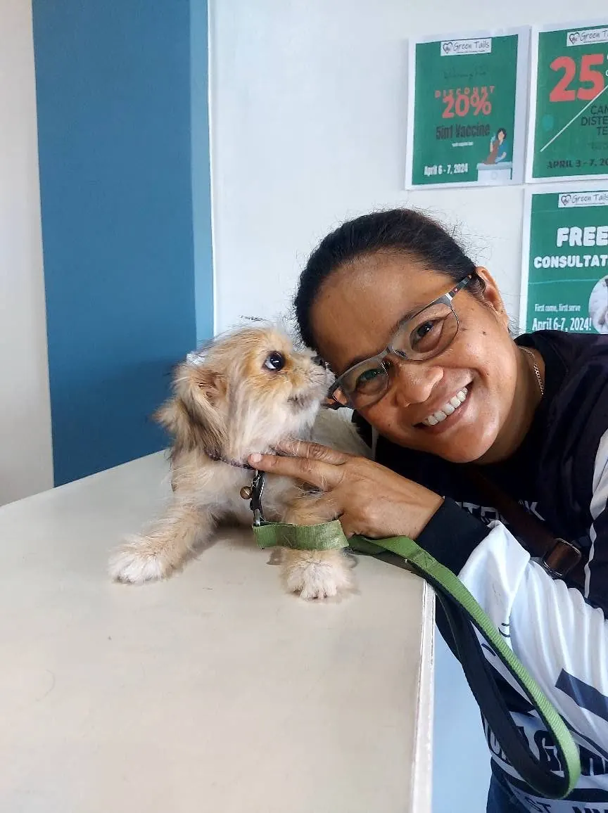 Green Tails team member cuddling a happy dog